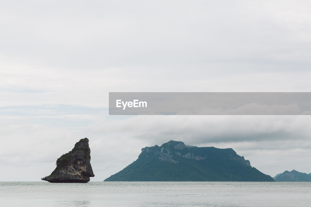 Scenic view of sea and mountains against sky