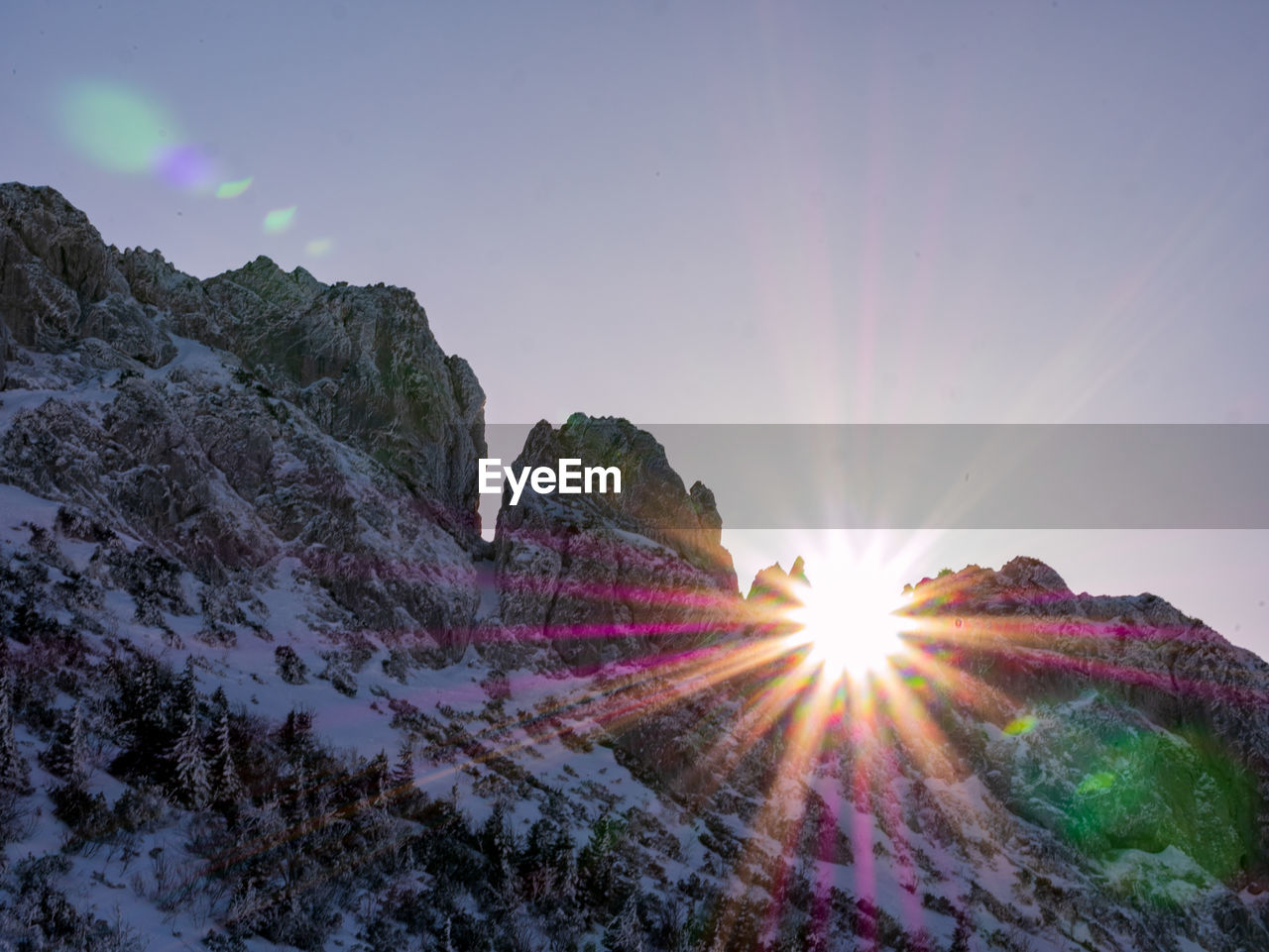 Sunlight streaming through rocks against bright sun