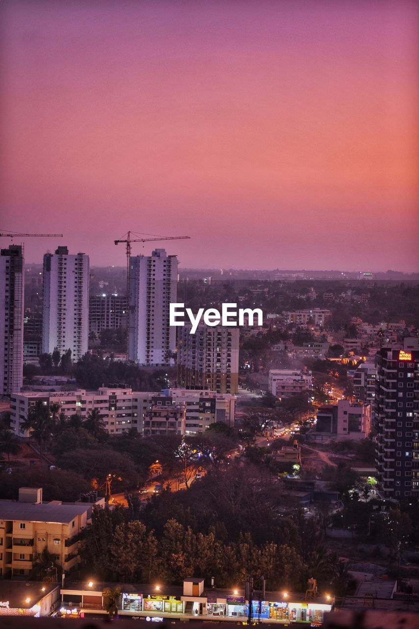 High angle view of illuminated buildings against sky at dusk