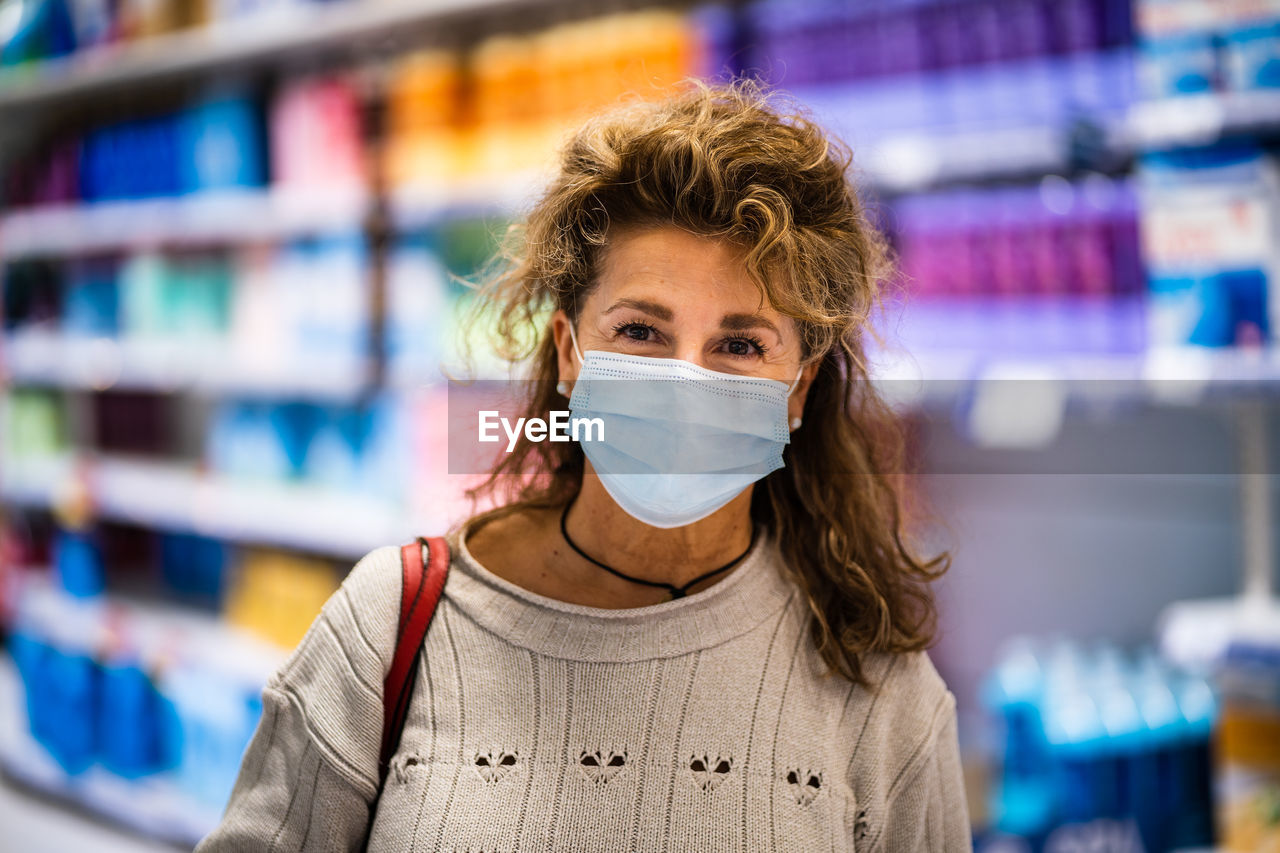 Portrait of woman wearing mask standing in store