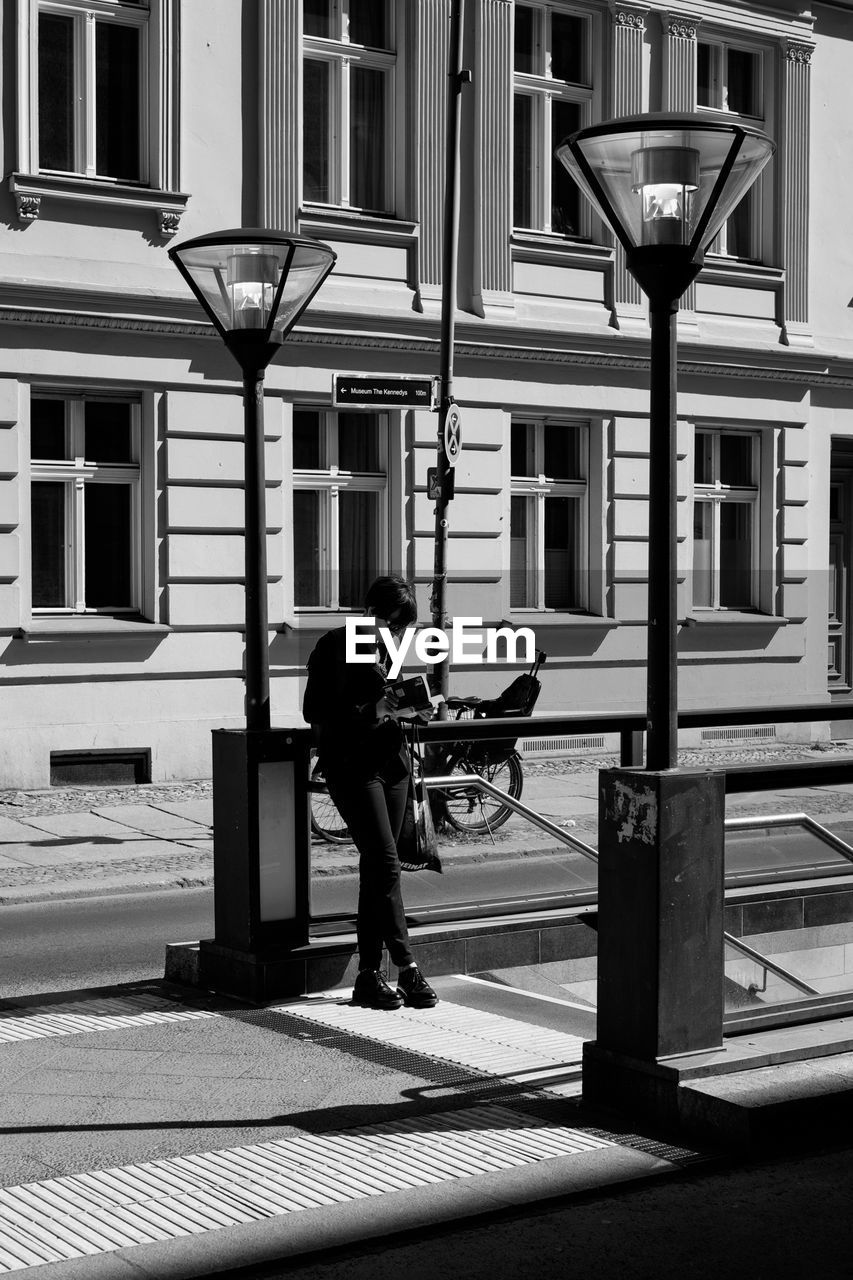 WOMAN STANDING IN FRONT OF BUILDING