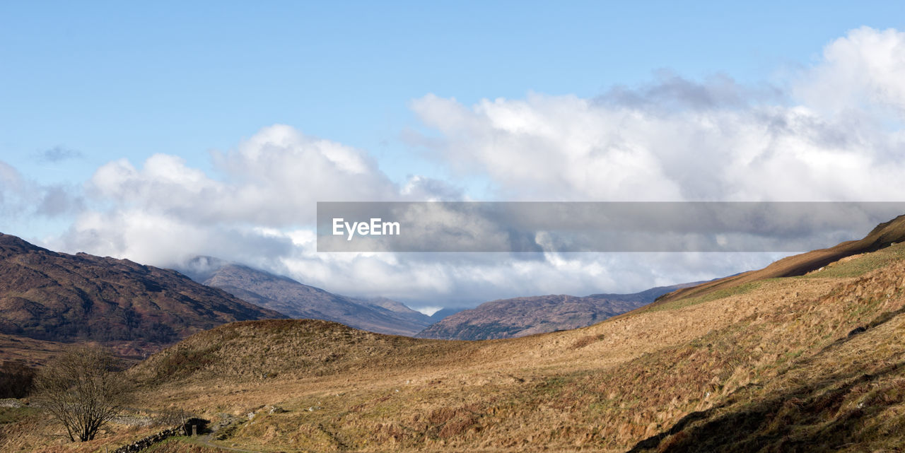 Scenic view of mountains against cloudy sky