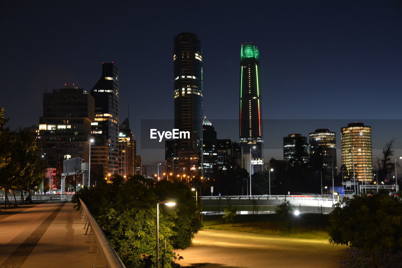 Illuminated cityscape against clear sky at night