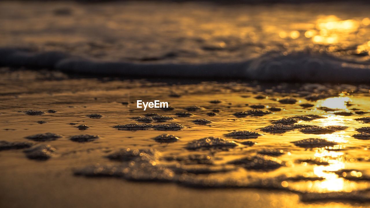 Close-up of water against sky at sunset