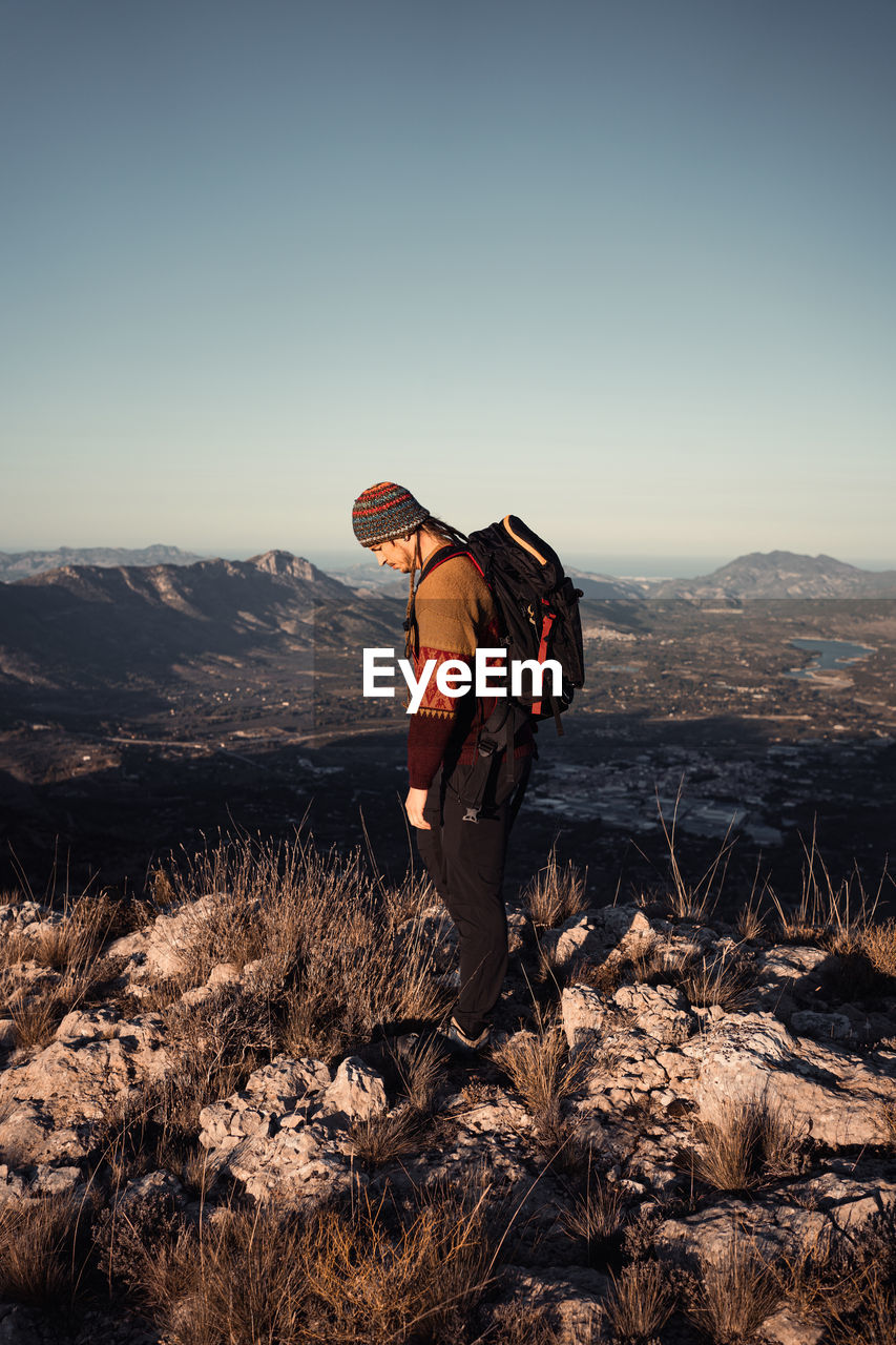 Full length of man standing on rock against sky