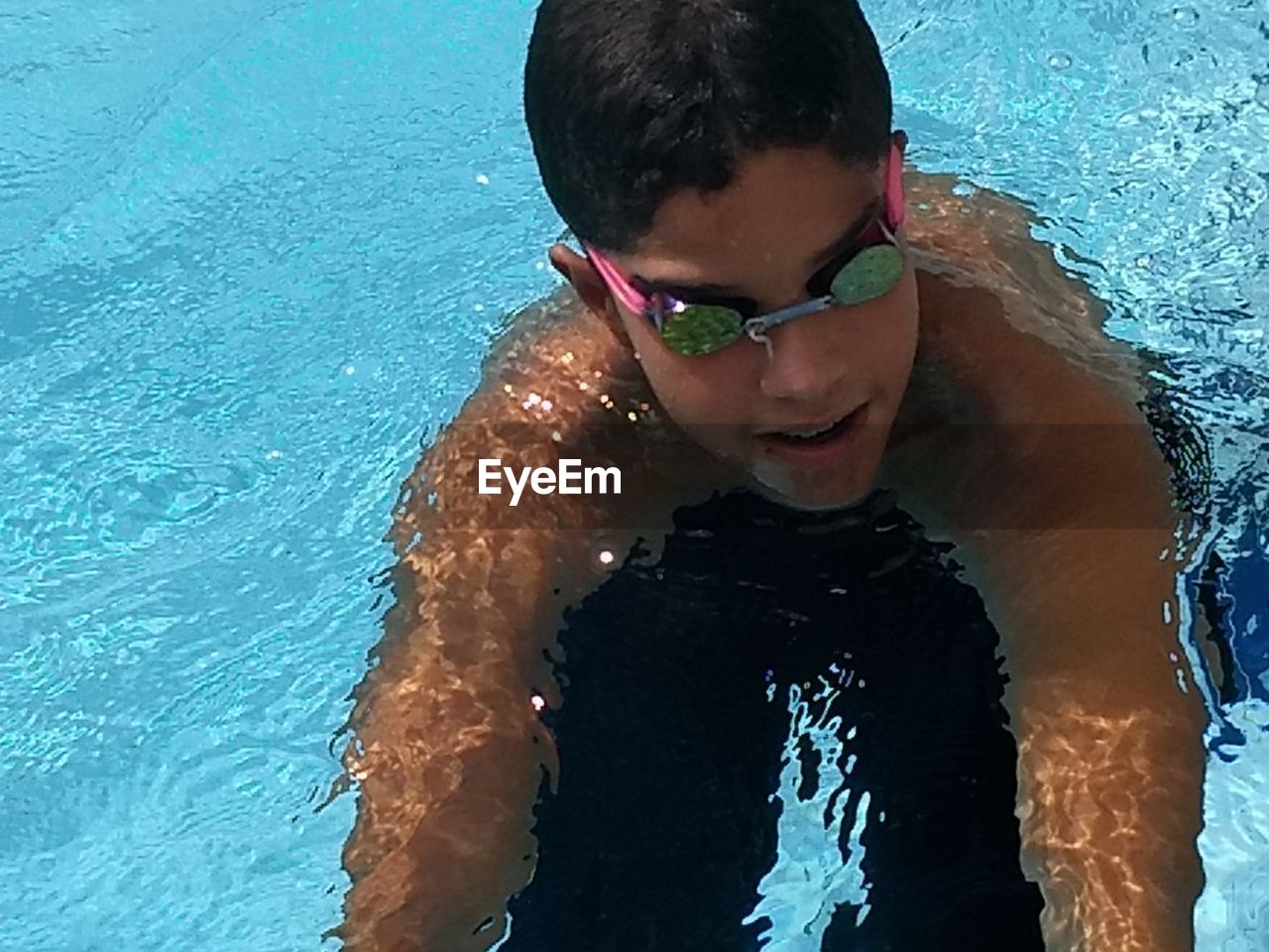 HIGH ANGLE VIEW OF MAN SWIMMING IN WATER