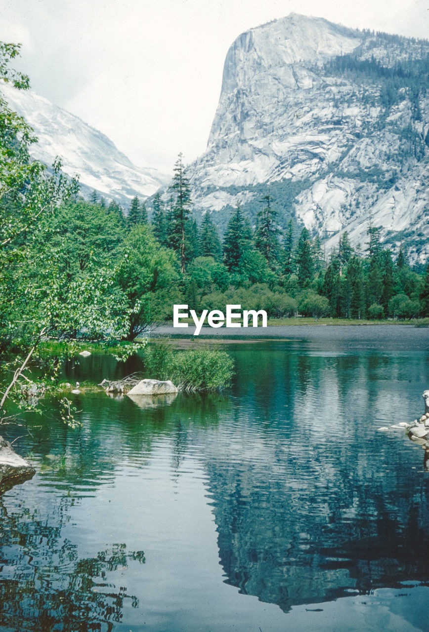 scenic view of lake by mountains against sky