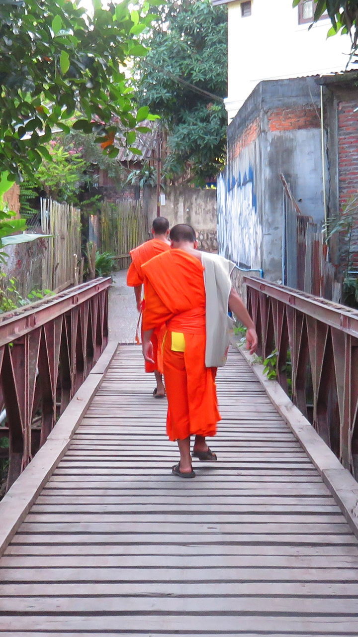 WOMAN WALKING ON FOOTBRIDGE