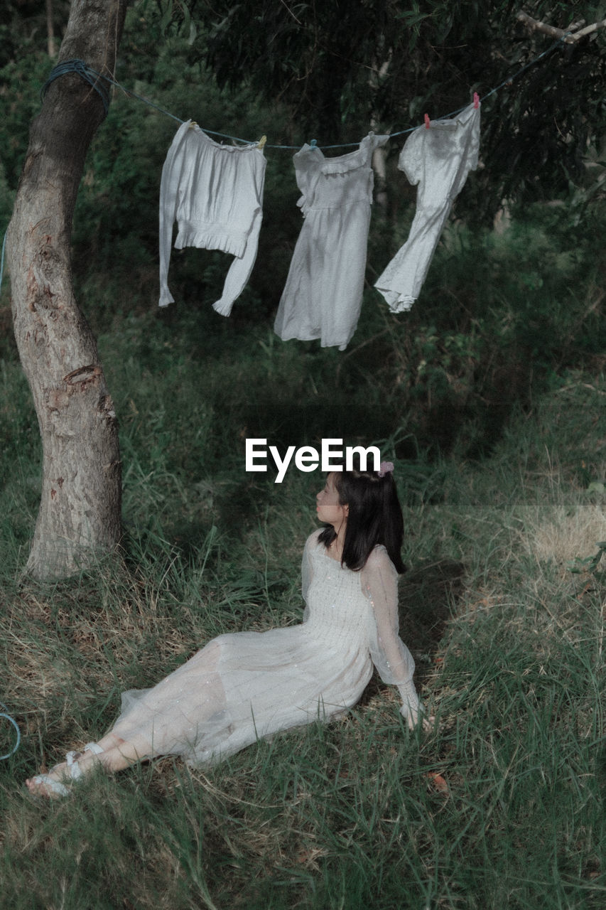 Full length of woman hanging on field in forest