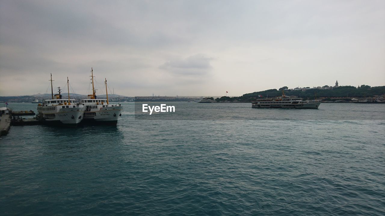 Boats moored in sea against sky