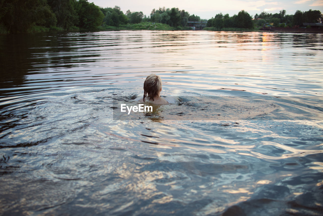 REFLECTION OF PERSON SWIMMING IN LAKE