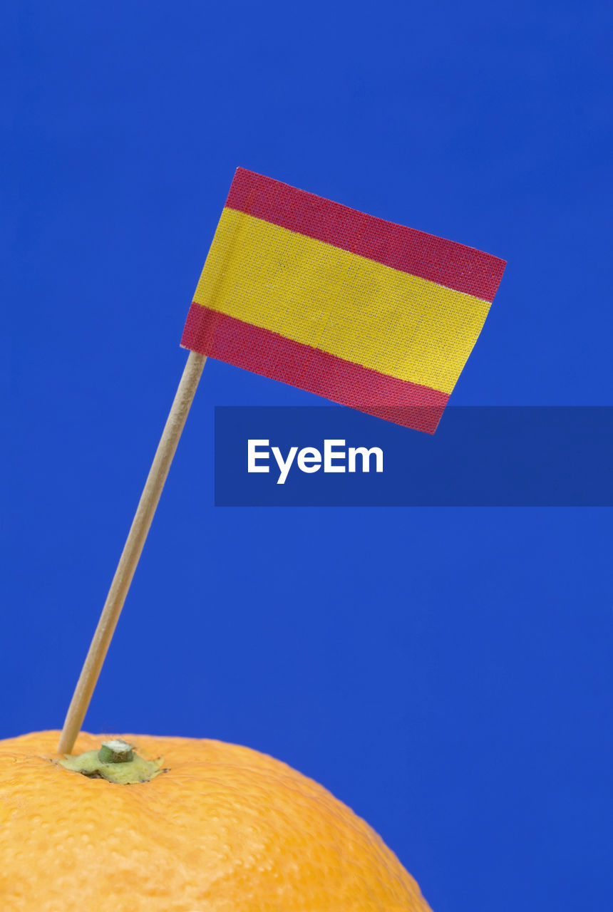 CLOSE-UP OF FLAGS AGAINST BLUE SKY