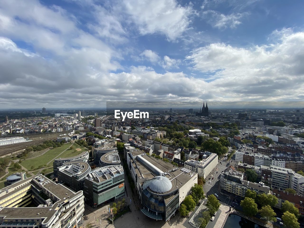 HIGH ANGLE VIEW OF BUILDINGS AGAINST CLOUDY SKY