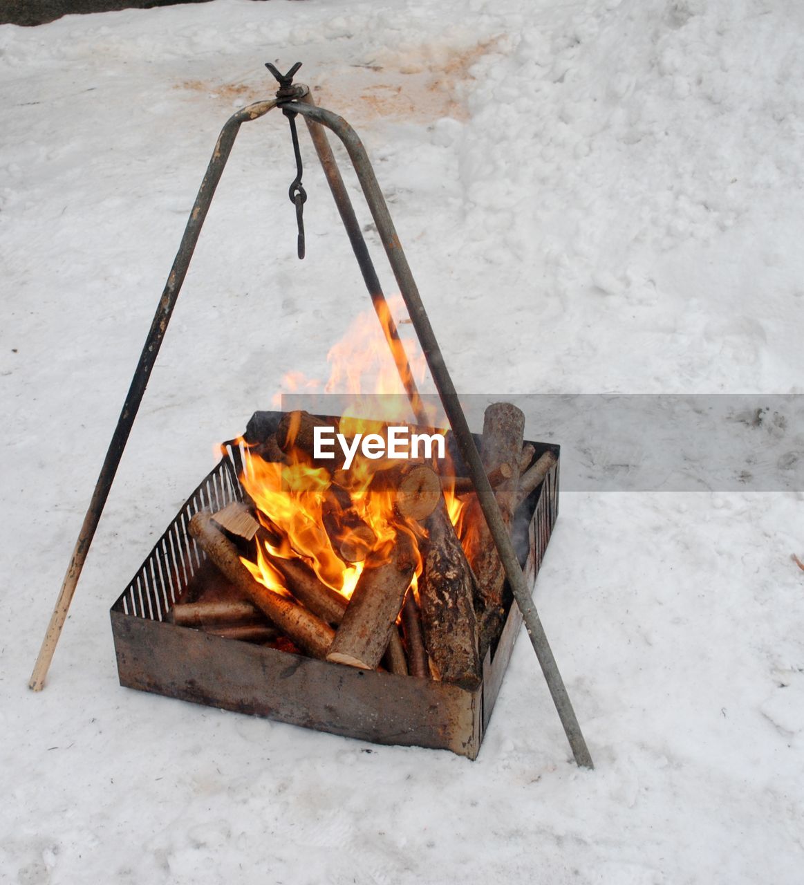Close-up of firewood burning in fire pit on snow
