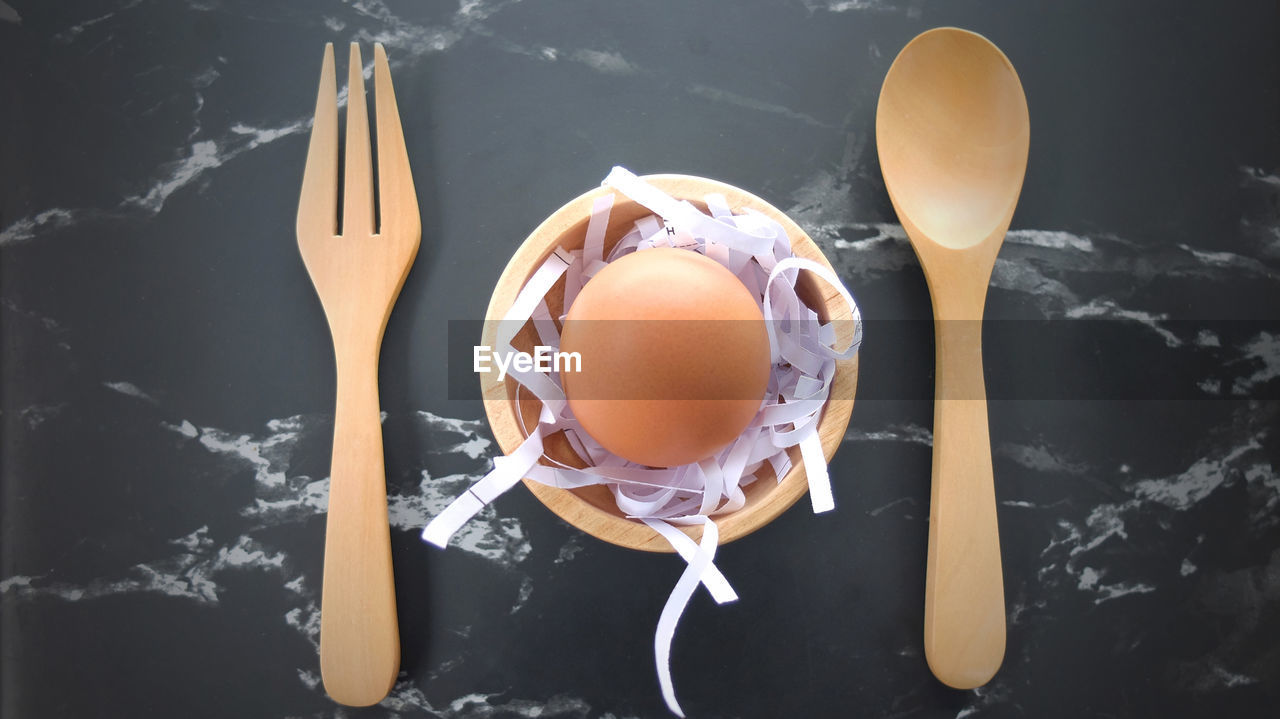 Closeup egg with wooden spoon on table, top view egg, ingredients cooking concept,