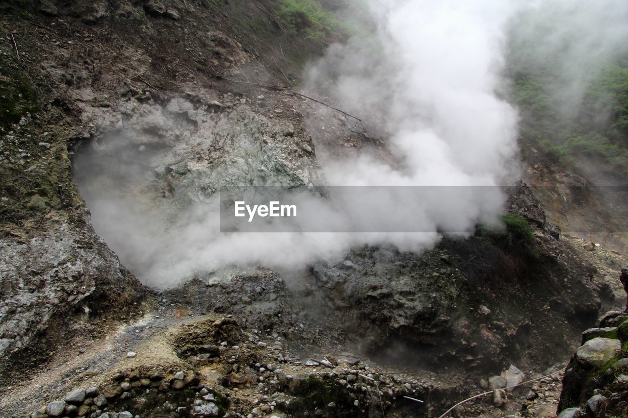 environment, smoke, geology, landscape, steam, beauty in nature, mountain, nature, non-urban scene, scenics - nature, no people, land, physical geography, volcano, heat, high angle view, water, outdoors, travel destinations, power in nature, volcanic landscape, rock, day, travel, fog, soil, hot spring, volcanic crater, plant, body of water, tourism