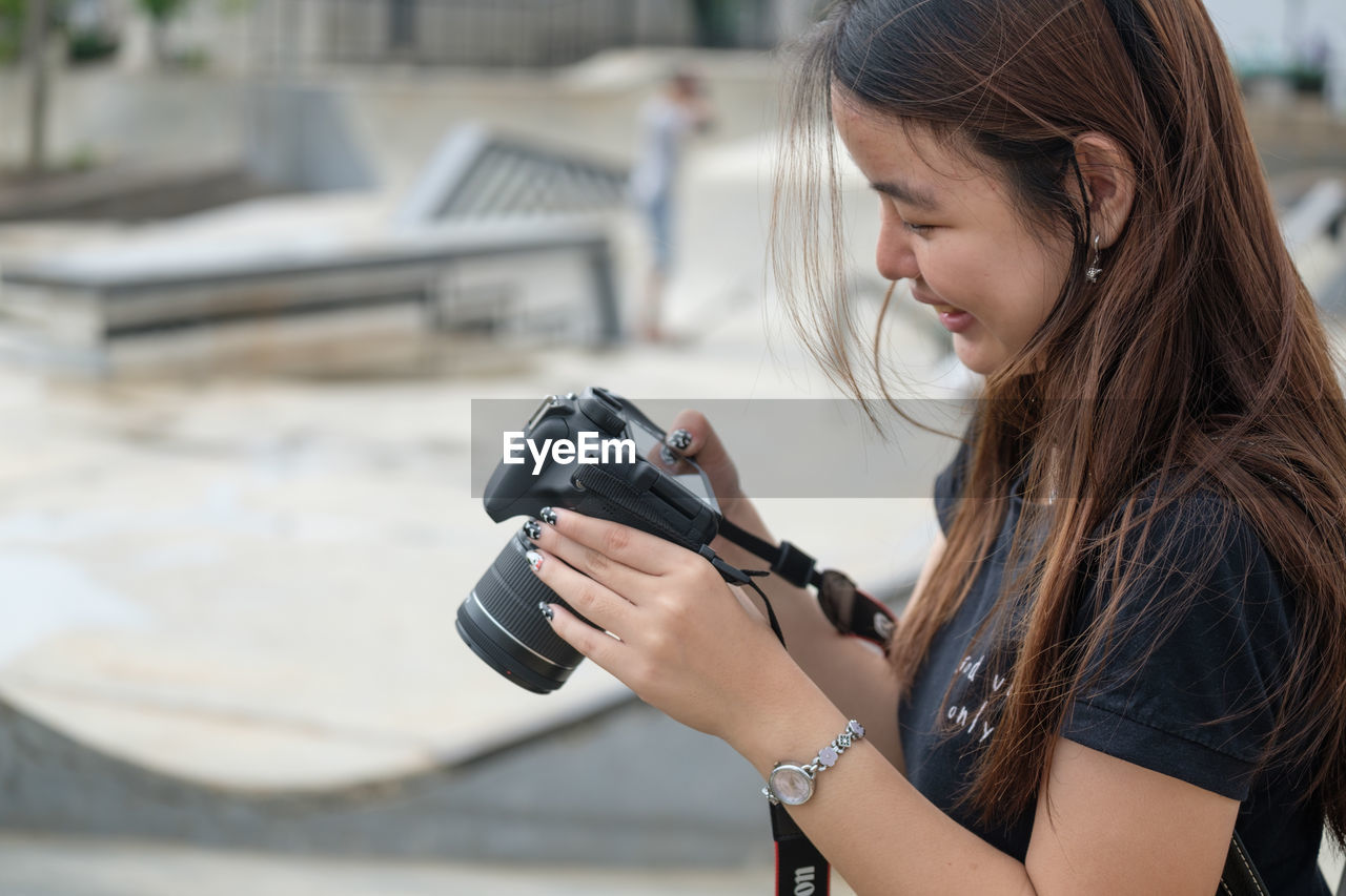 SIDE VIEW OF MAN PHOTOGRAPHING AGAINST CAMERA