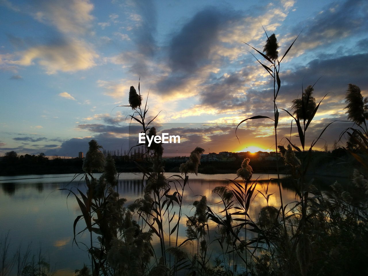 SCENIC VIEW OF LAKE AGAINST SKY AT SUNSET