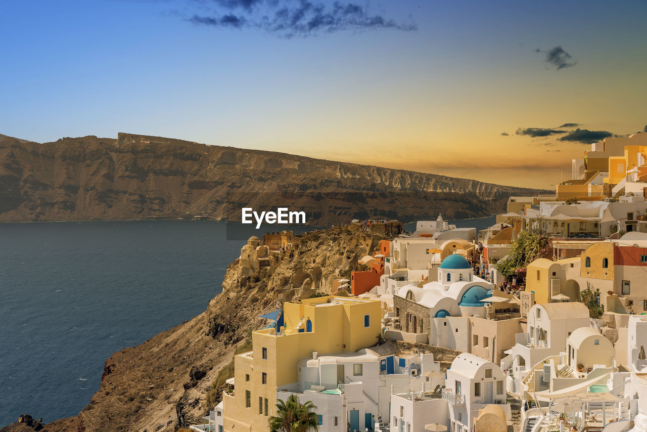 High angle view of town by sea against sky