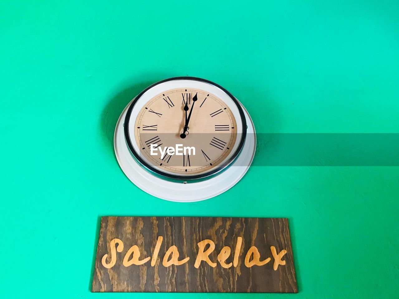 Close-up of wall clock and text on blue background