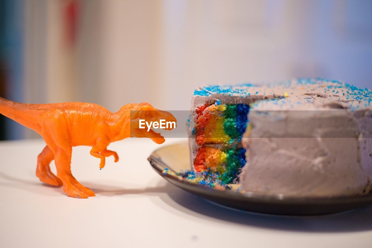 Close-up of toy and cake in plate on table