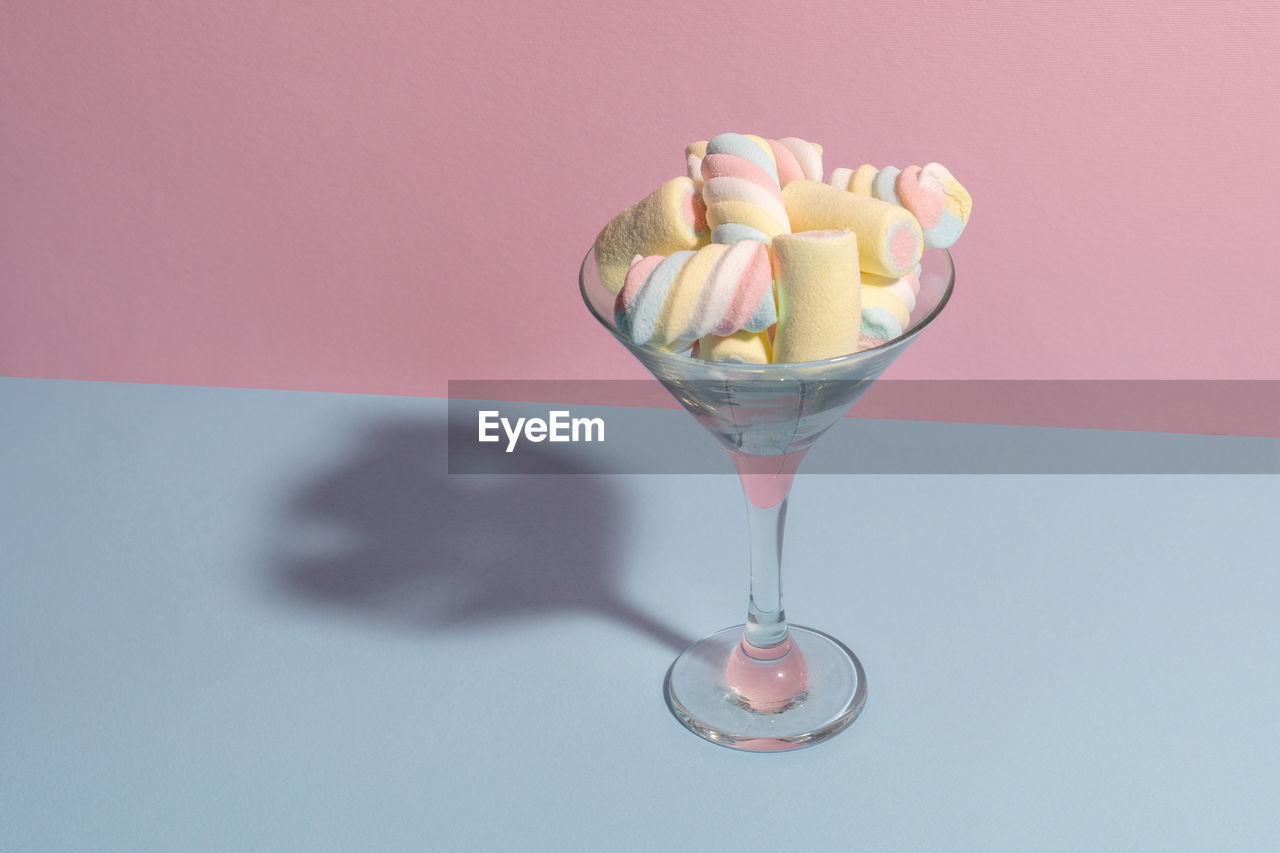 Colorful marshmallows in a martini glass. pastel blue and pink colors