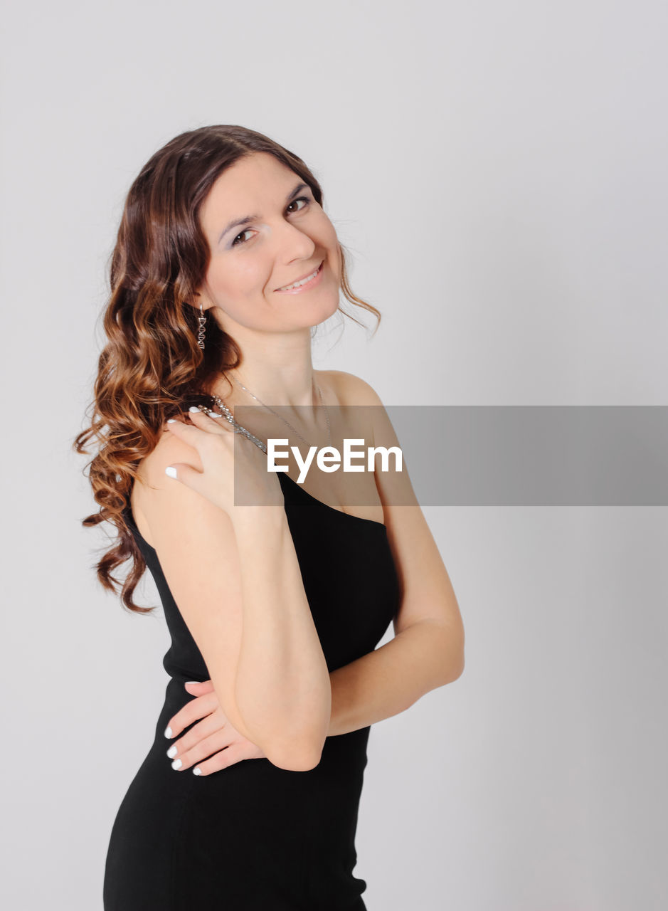 Portrait of smiling woman standing over white background