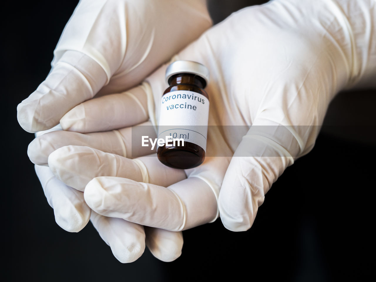 Doctor's hand holding a syringe of covid-19 vaccine and vaccine vial