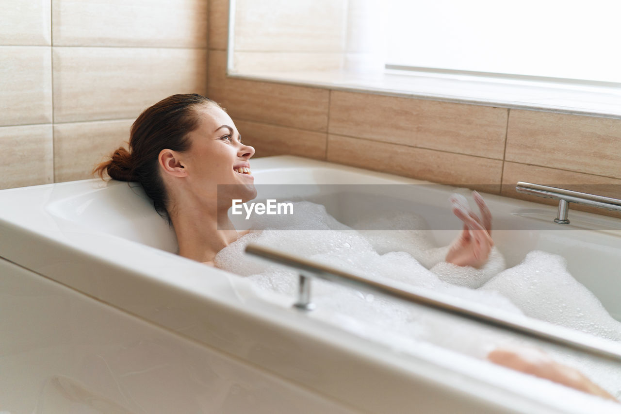 Smiling woman in bathtub