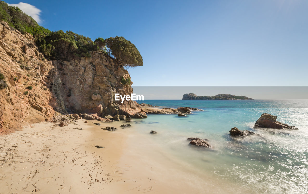 Scenic view of rock formations and sea against clear sky