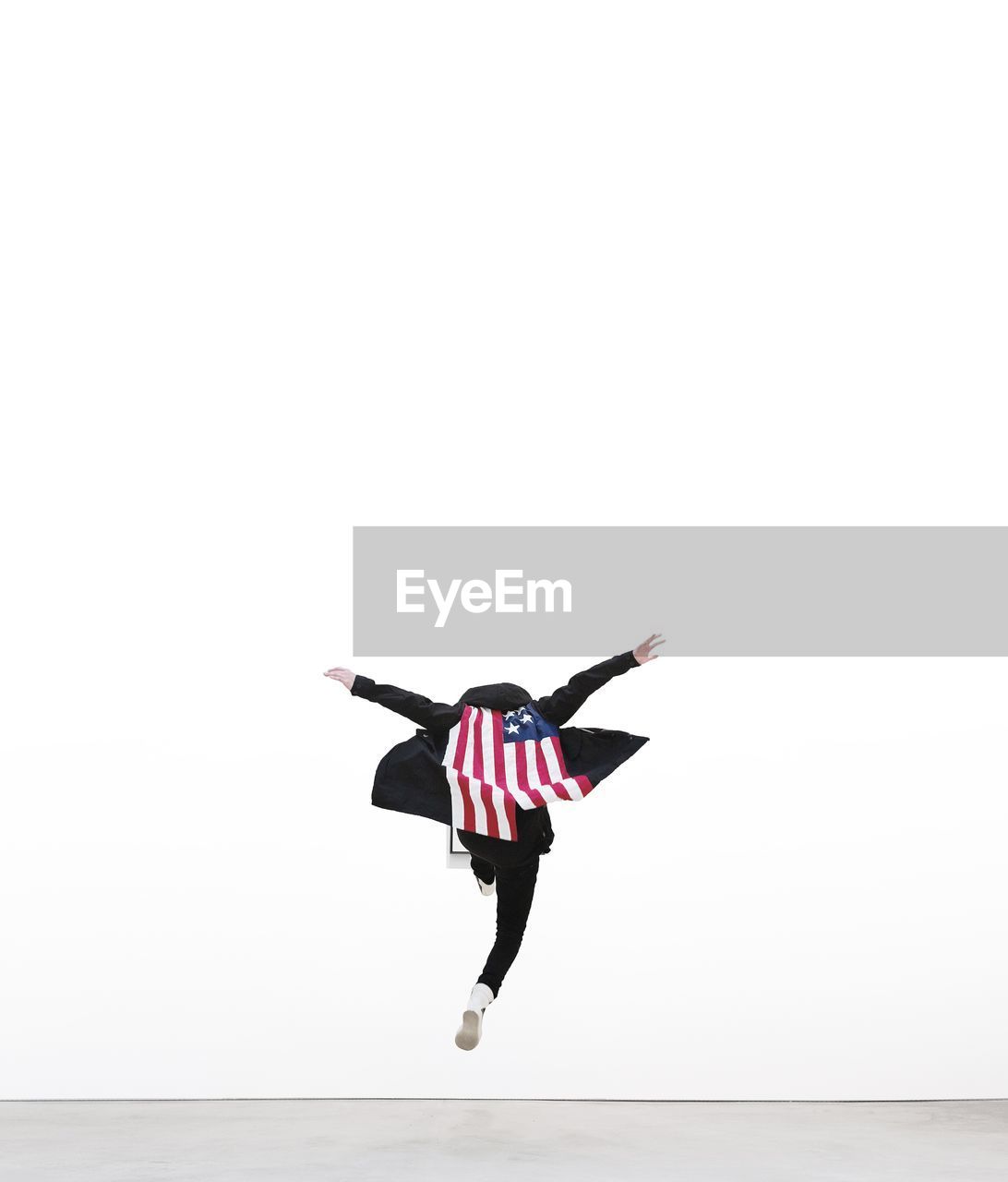 Man in american flag jumping over white background