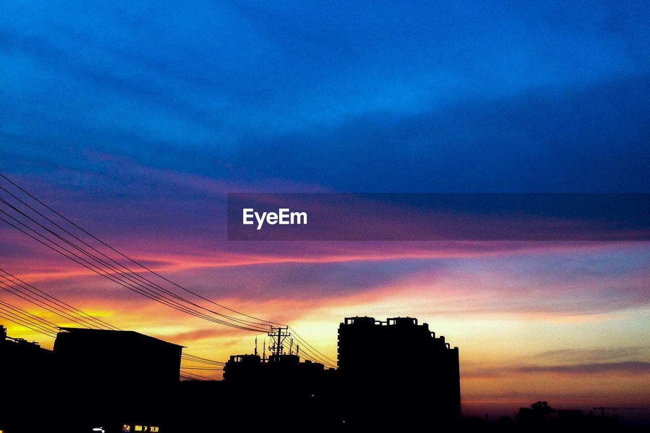 LOW ANGLE VIEW OF BUILT STRUCTURE AGAINST SKY AT SUNSET