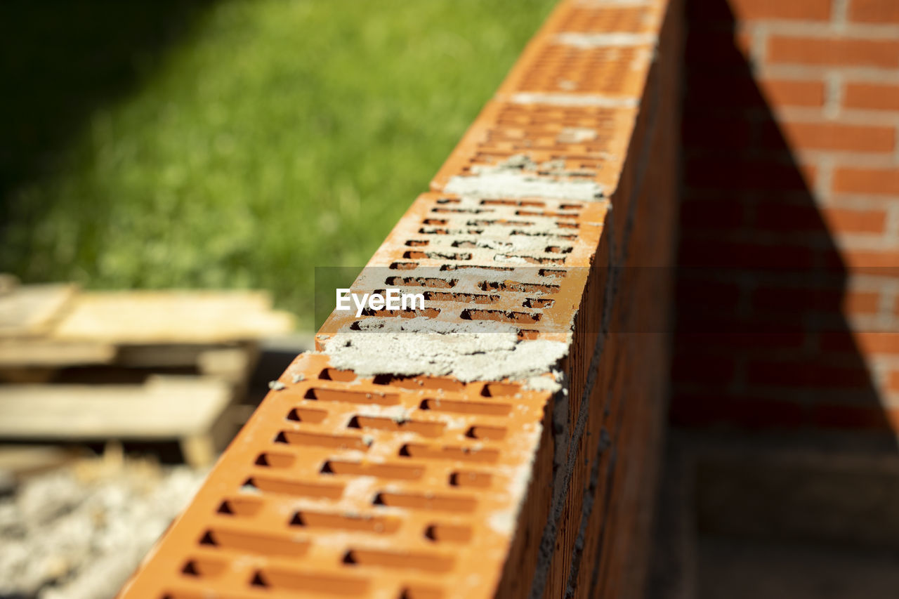 wood, no people, brick, selective focus, day, focus on foreground, close-up, sunlight, nature, outdoors, architecture