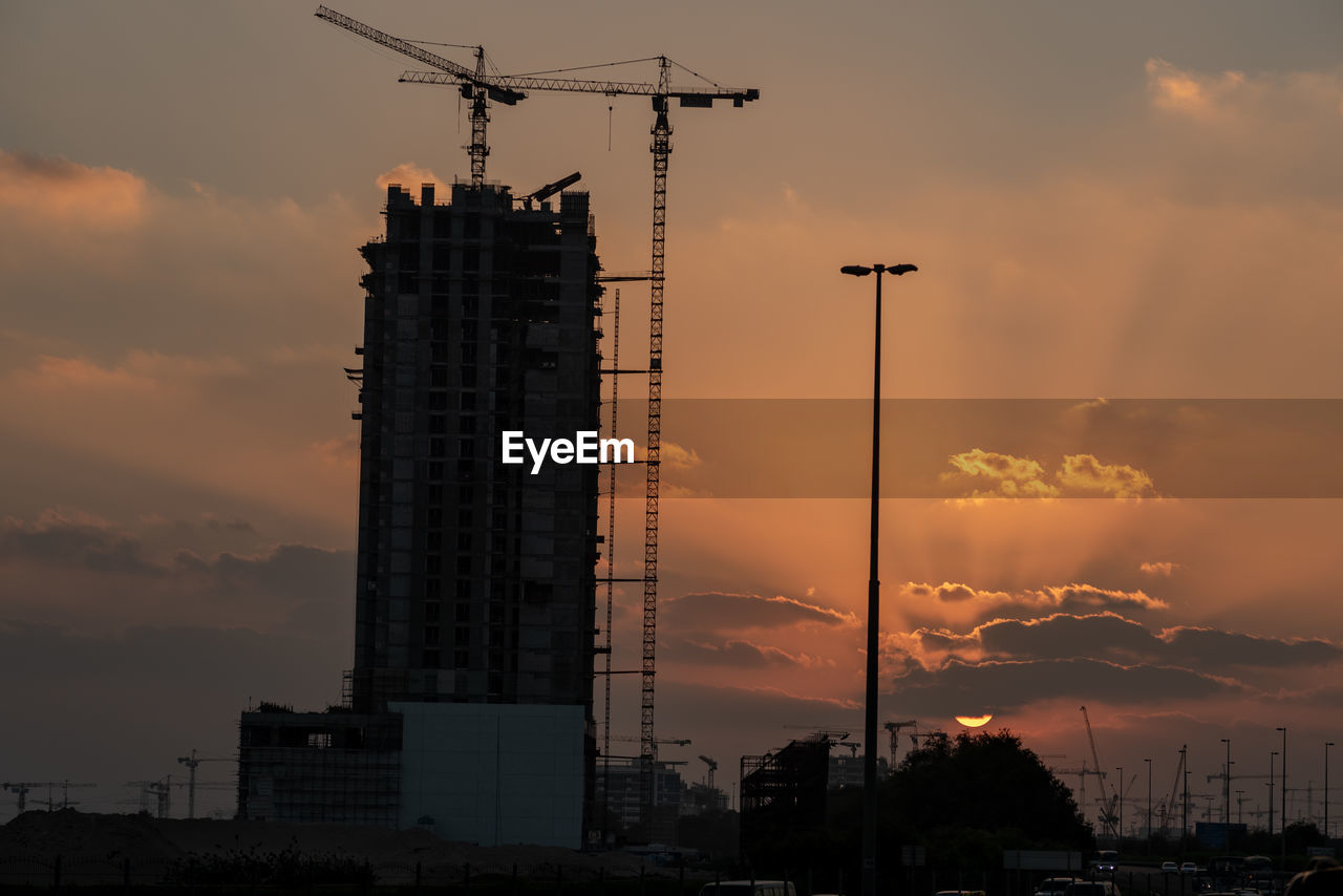 LOW ANGLE VIEW OF SILHOUETTE BUILDINGS AGAINST SKY AT SUNSET