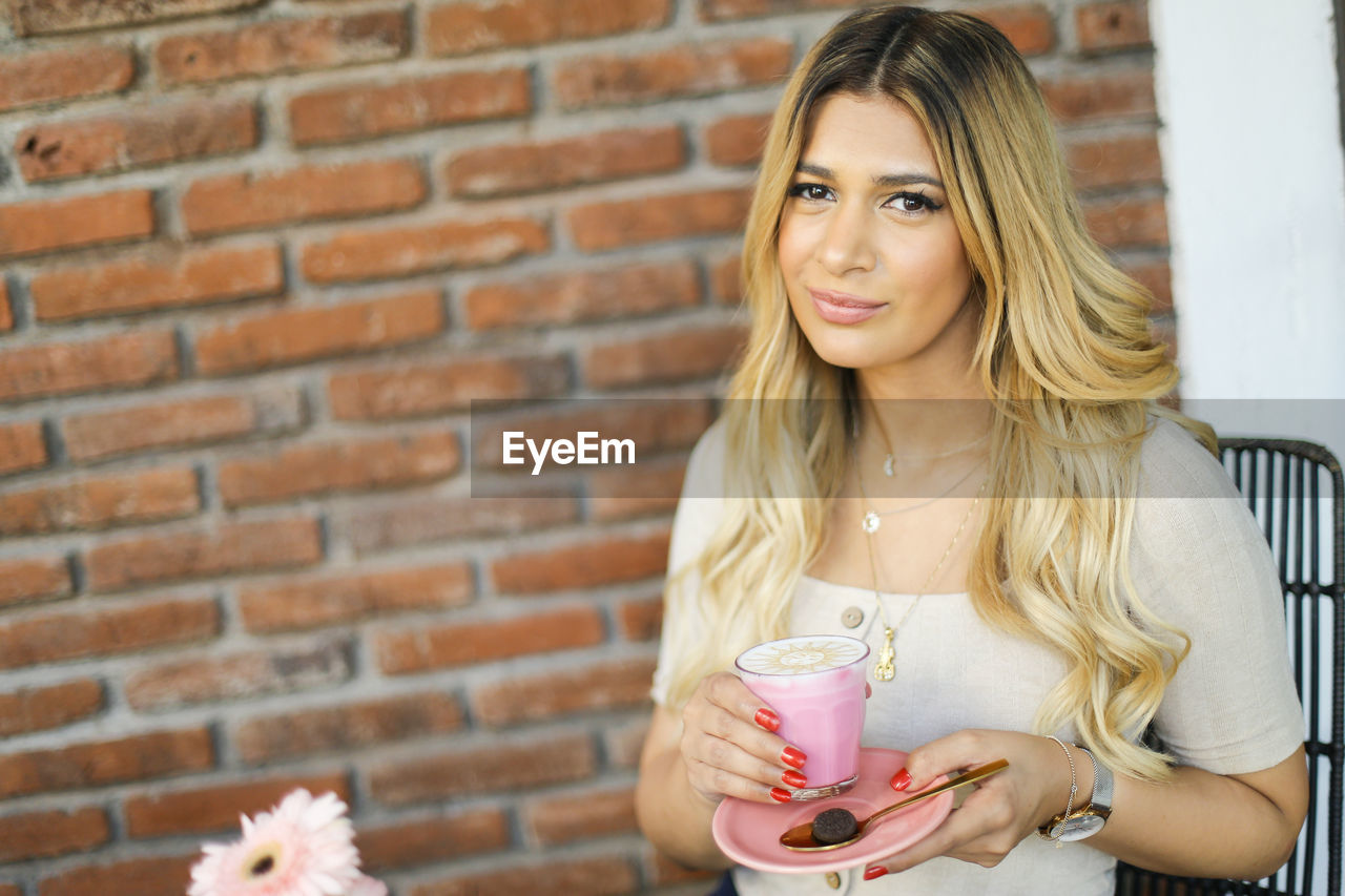 PORTRAIT OF A BEAUTIFUL YOUNG WOMAN WITH COFFEE