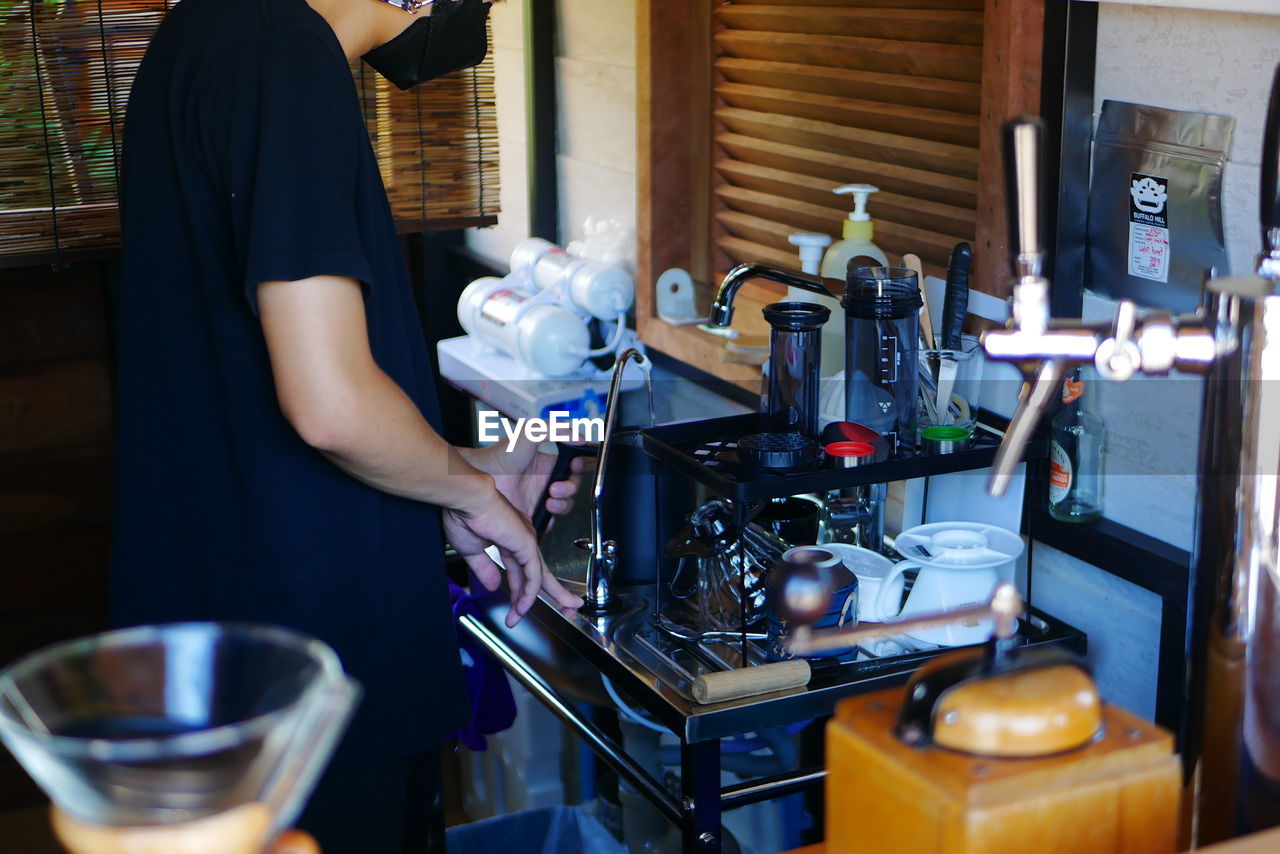 MIDSECTION OF MAN WORKING IN KITCHEN AT HOME