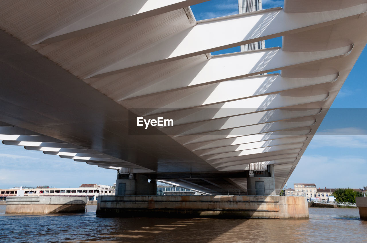 LOW ANGLE VIEW OF BRIDGE OVER RIVER AGAINST SKY