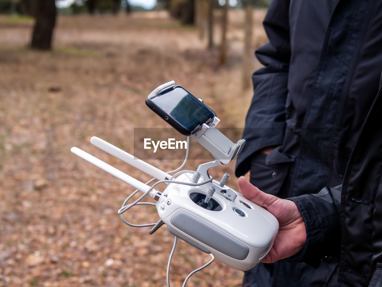 Midsection of man using drone remote control on land