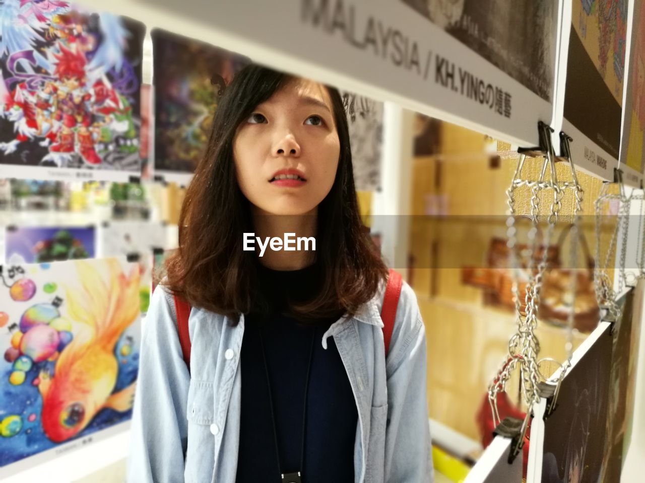 CLOSE-UP OF YOUNG WOMAN STANDING BY STORE IN A SHOP