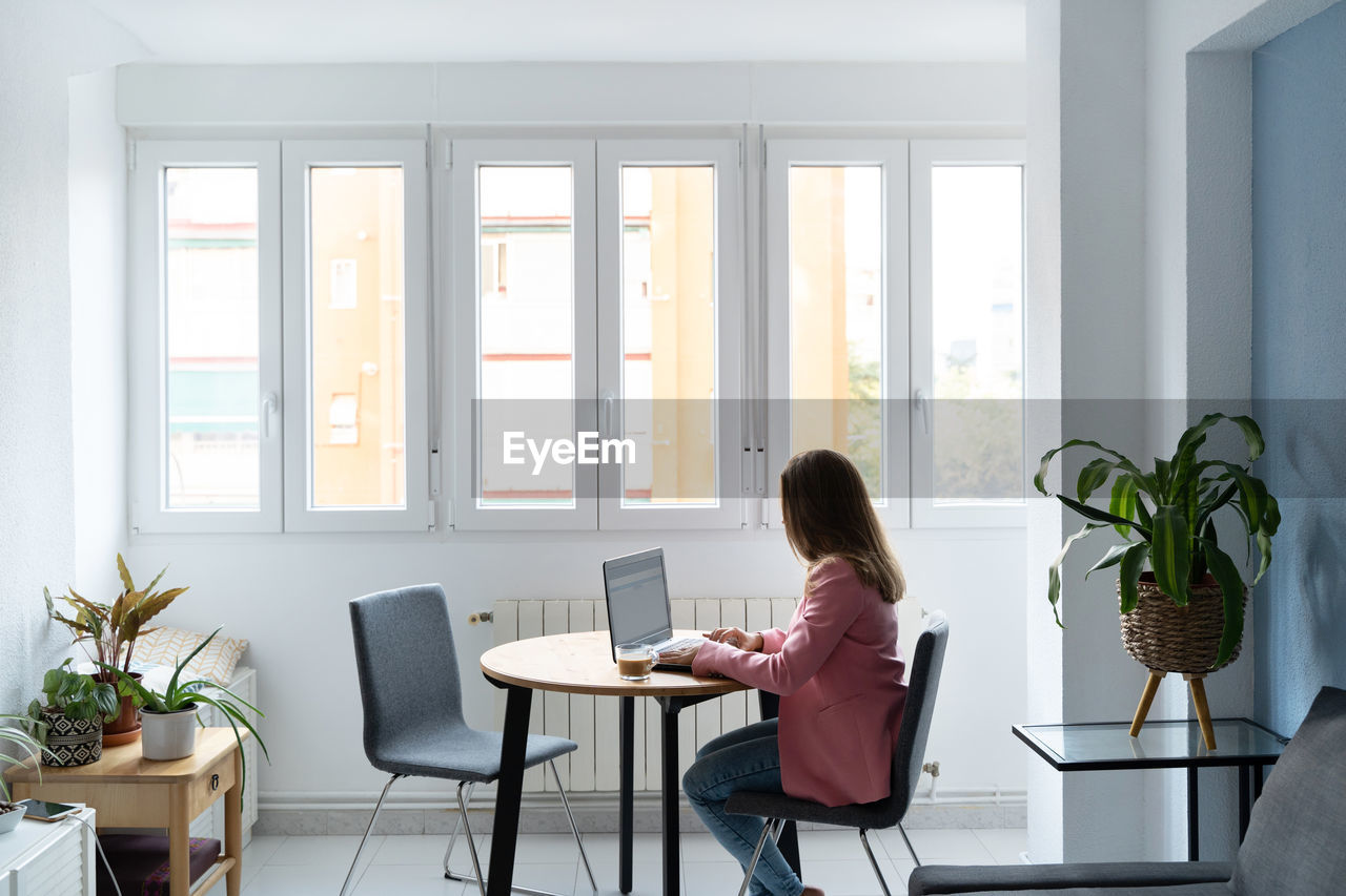 Woman sitting on table at home