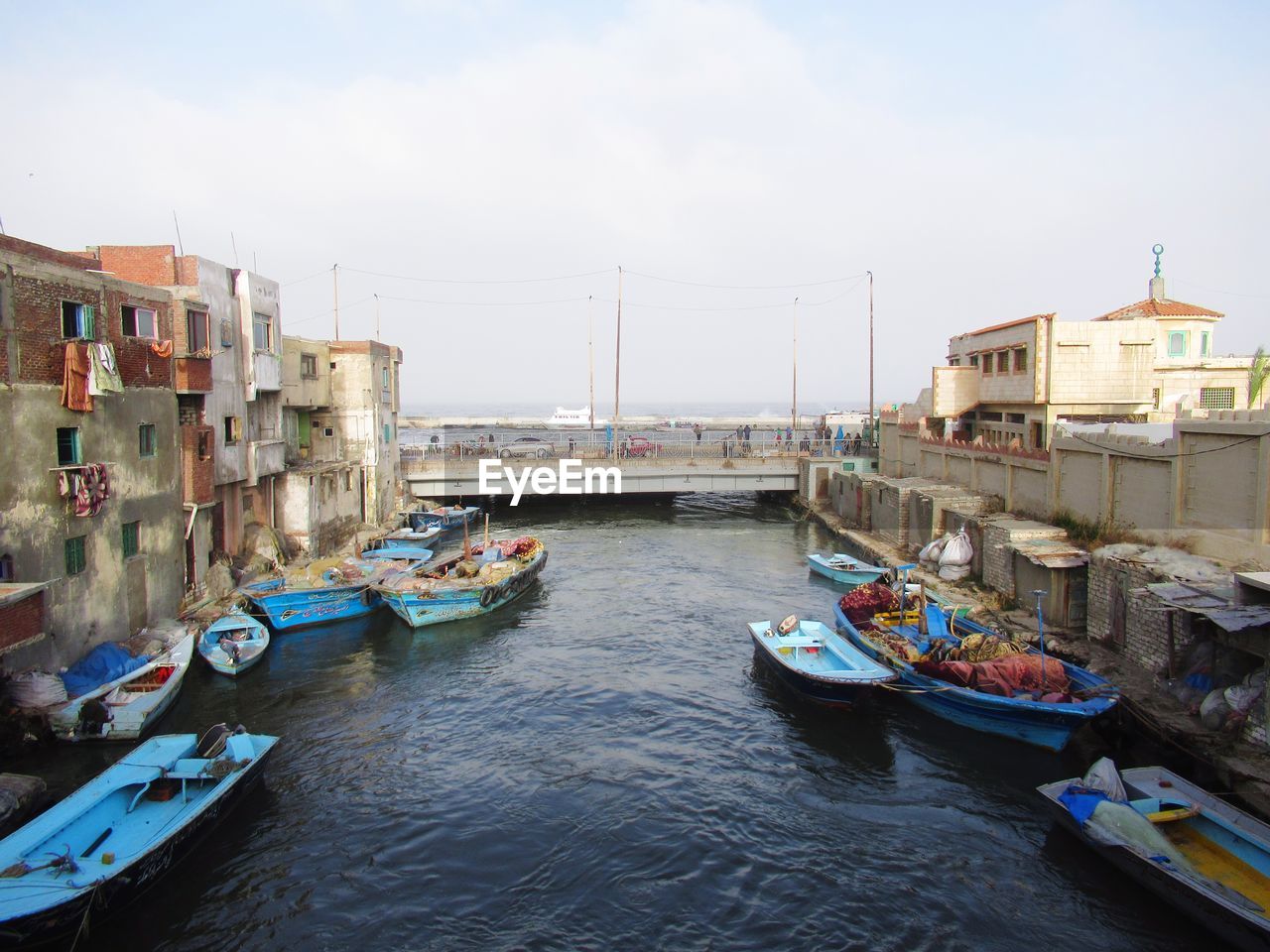 HIGH ANGLE VIEW OF BOATS MOORED IN SEA AGAINST SKY