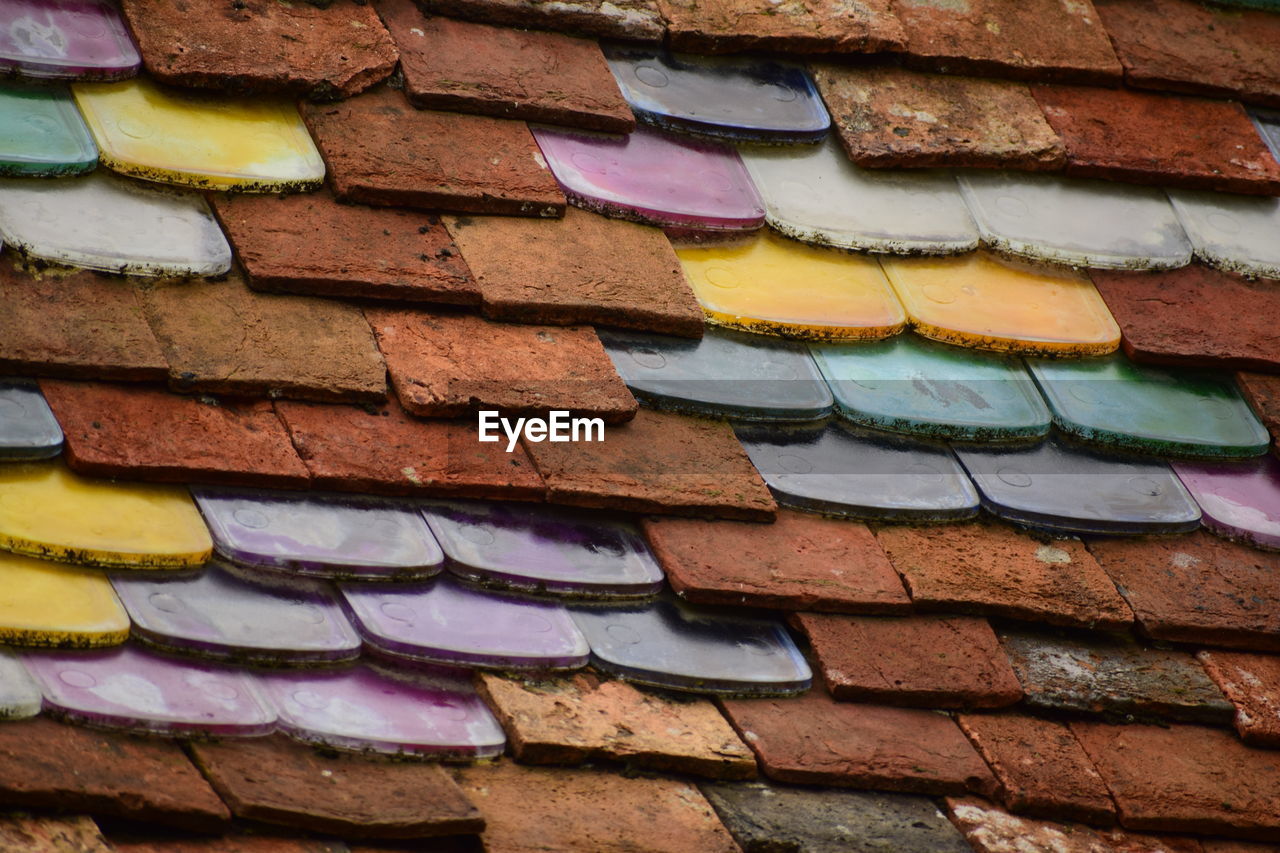 FULL FRAME SHOT OF MULTI COLORED WALL WITH BUILDING