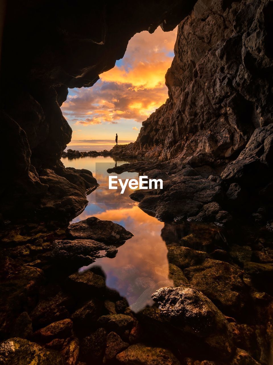 Sea seen through cave during sunset