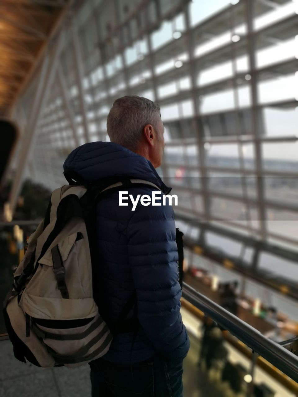 Side view of man standing at airport terminal