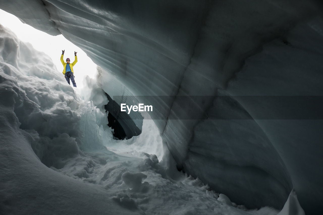 Fun portrait of climber, paul mcsorley seen through glacial crevasse.