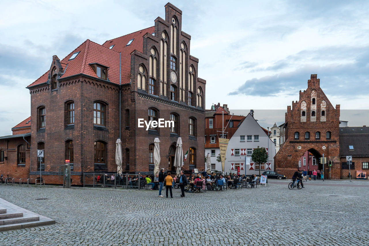 PEOPLE ON STREET AMIDST BUILDINGS IN CITY