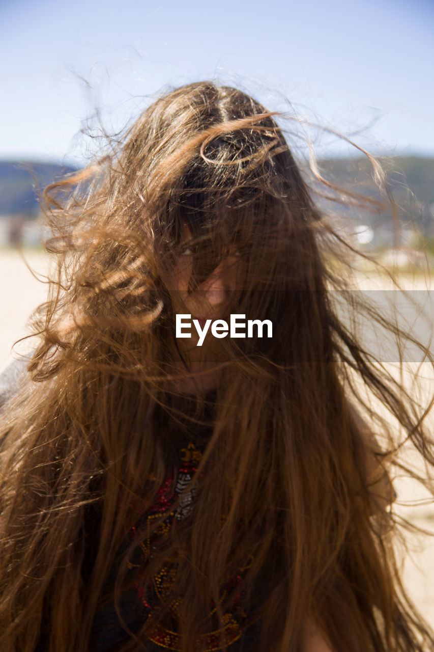 Portrait of girl with tousled hair while standing at beach