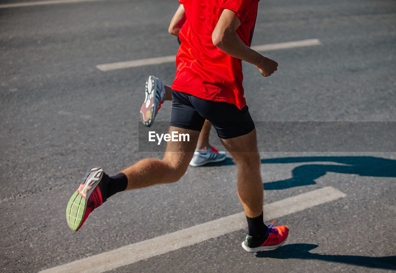 low section of man walking on road