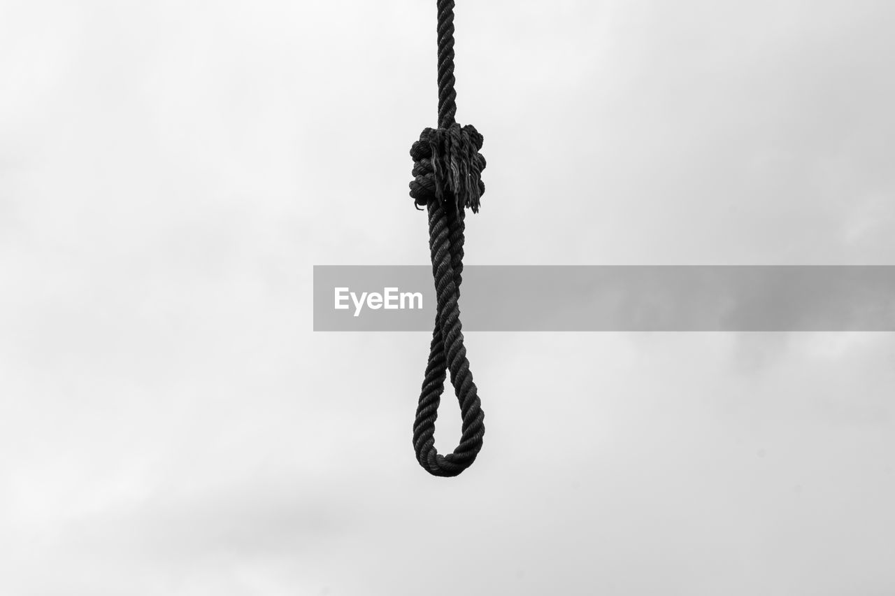 CLOSE-UP OF CHAIN TIED UP ROPE