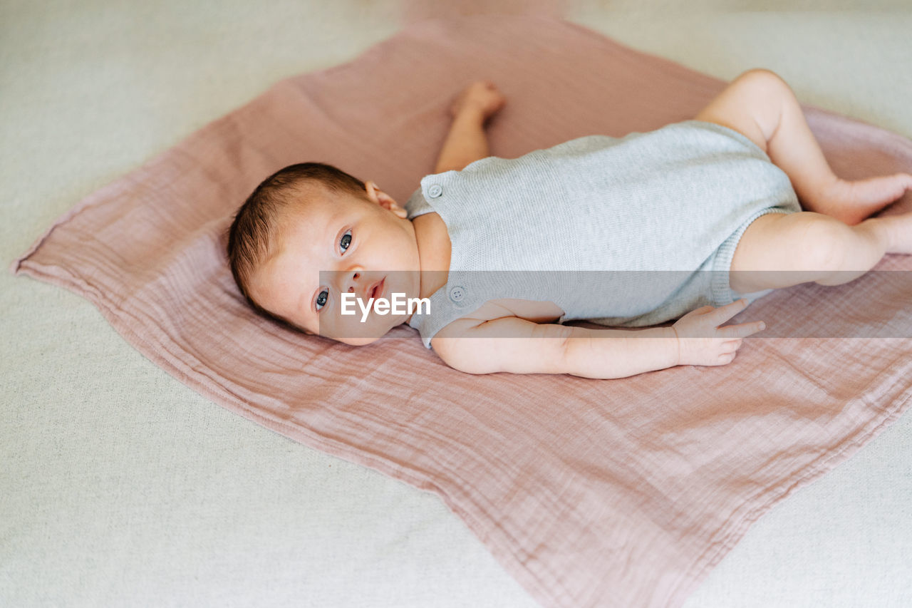 Portrait of cute baby lying on bed